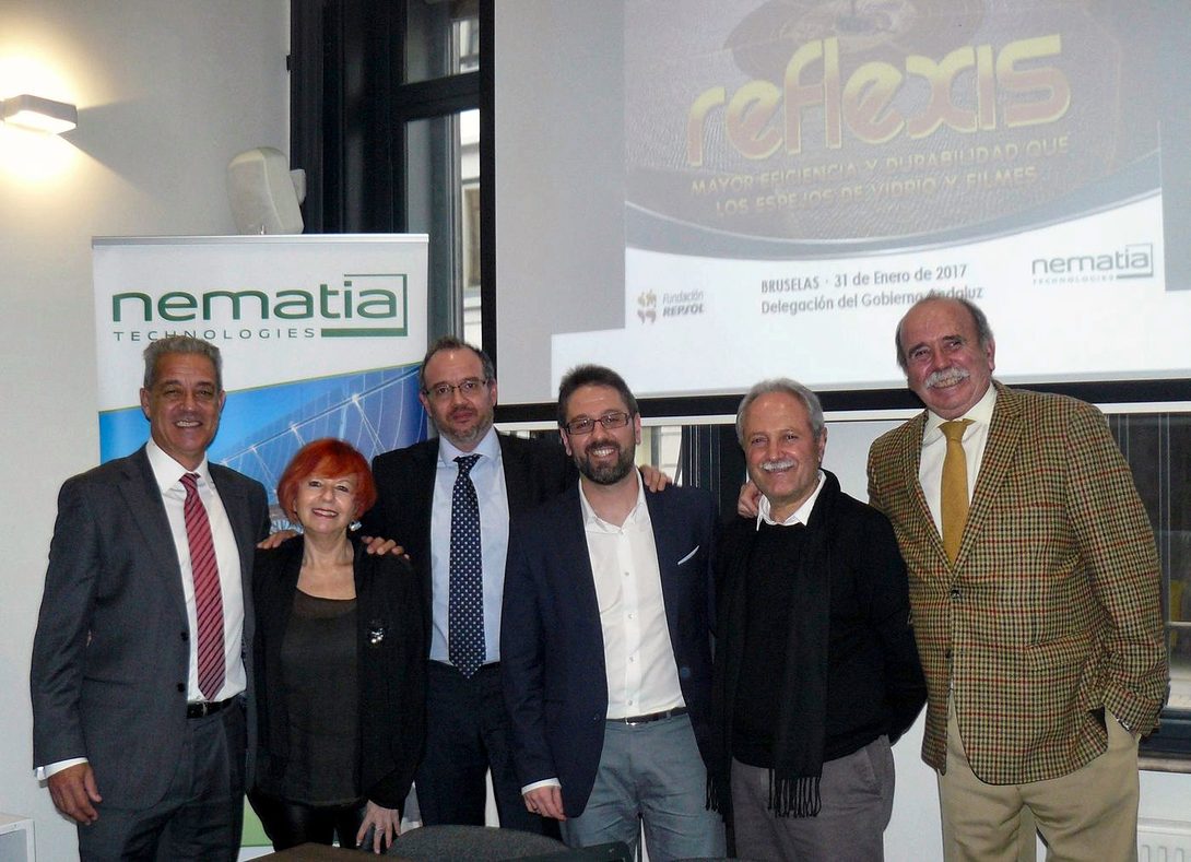 Seven people pose in front of a screen showing the REFLEXIS presentation and the Nematia and Junta de Andalucía roll-ups