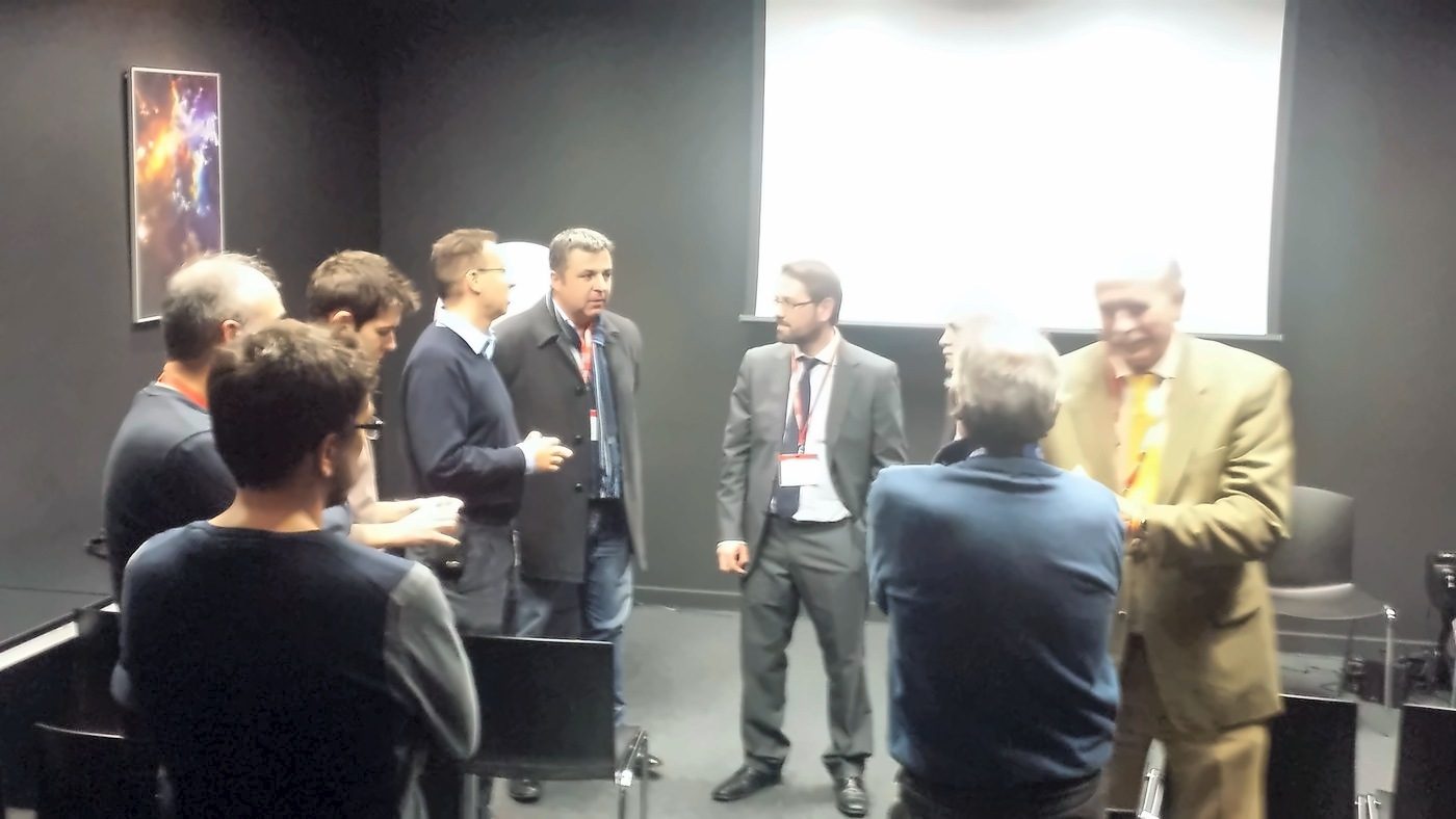 Group of people talking on their feet in a room after the talk
