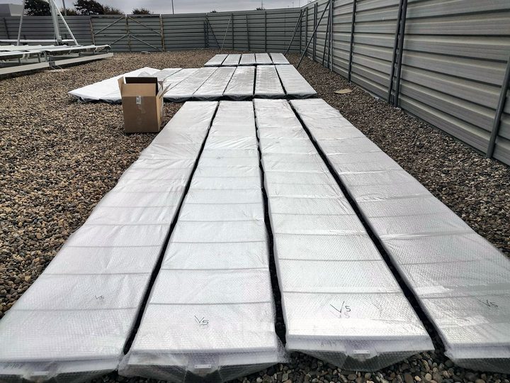 Mirrors of 0.5 by 0.25 metres packed in rows on the gravel of the pilot plant