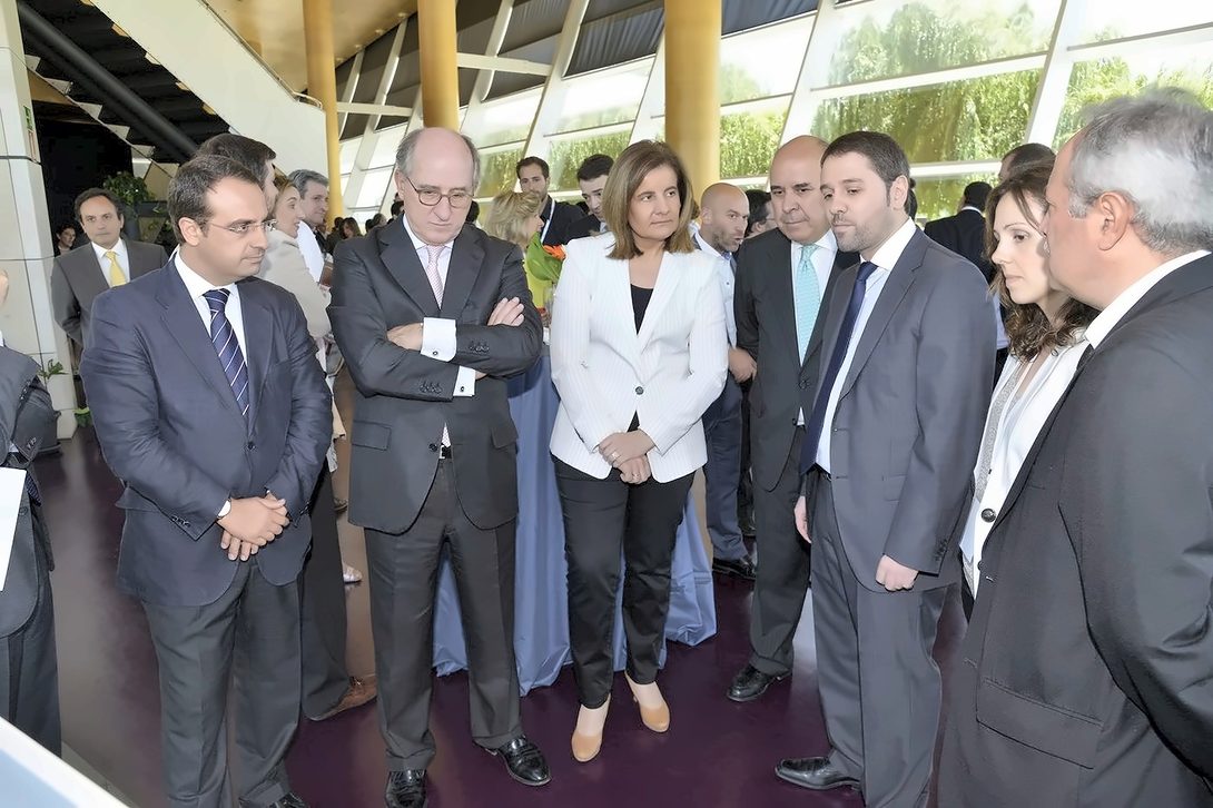 Alejandro Donaire explains the project to Minister Fátima Báñez and Antonio Brufau, surrounded by attendees