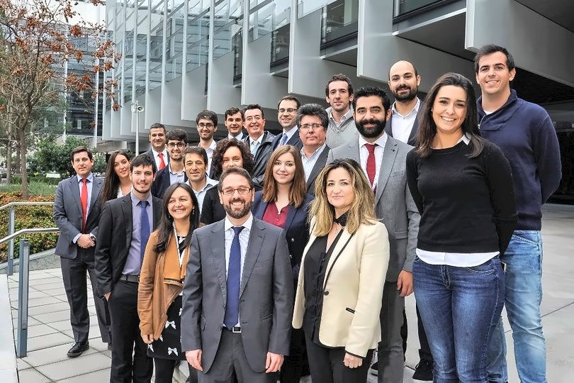 About thirty entrepreneurs pose on the forecourt of an office campus