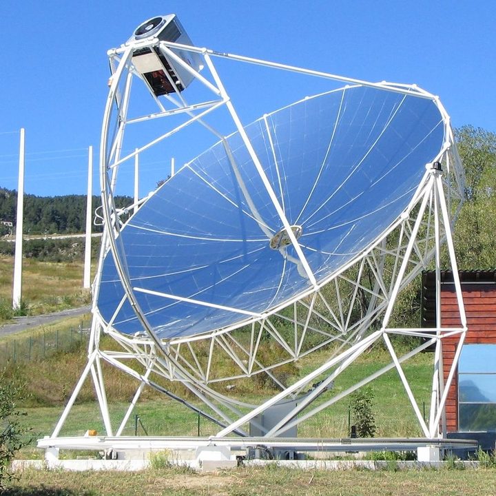 Parabolic mirror dish on a white steel structure, with the Stirling engine at its focus