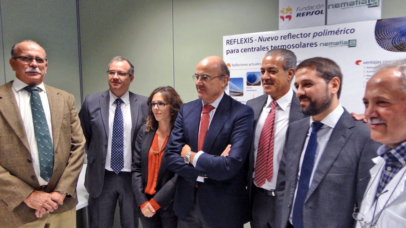 A group of people in suits poses in front of the REFLEXIS panel with the Fundación Repsol and Nematia logos