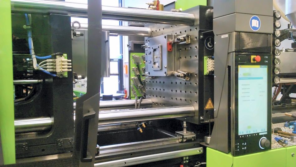 Sample mould mounted between the platens of an industrial injection moulding machine