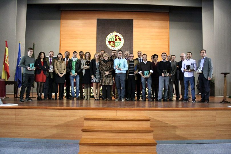 Group photo of award winners and officials on the stage of a university assembly hall